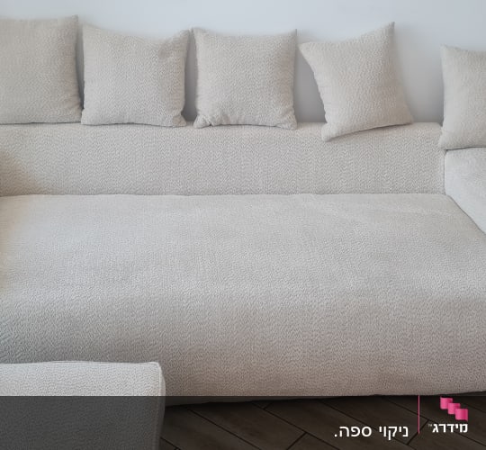 ספה גדולה עם כריות על רצפת עץ
